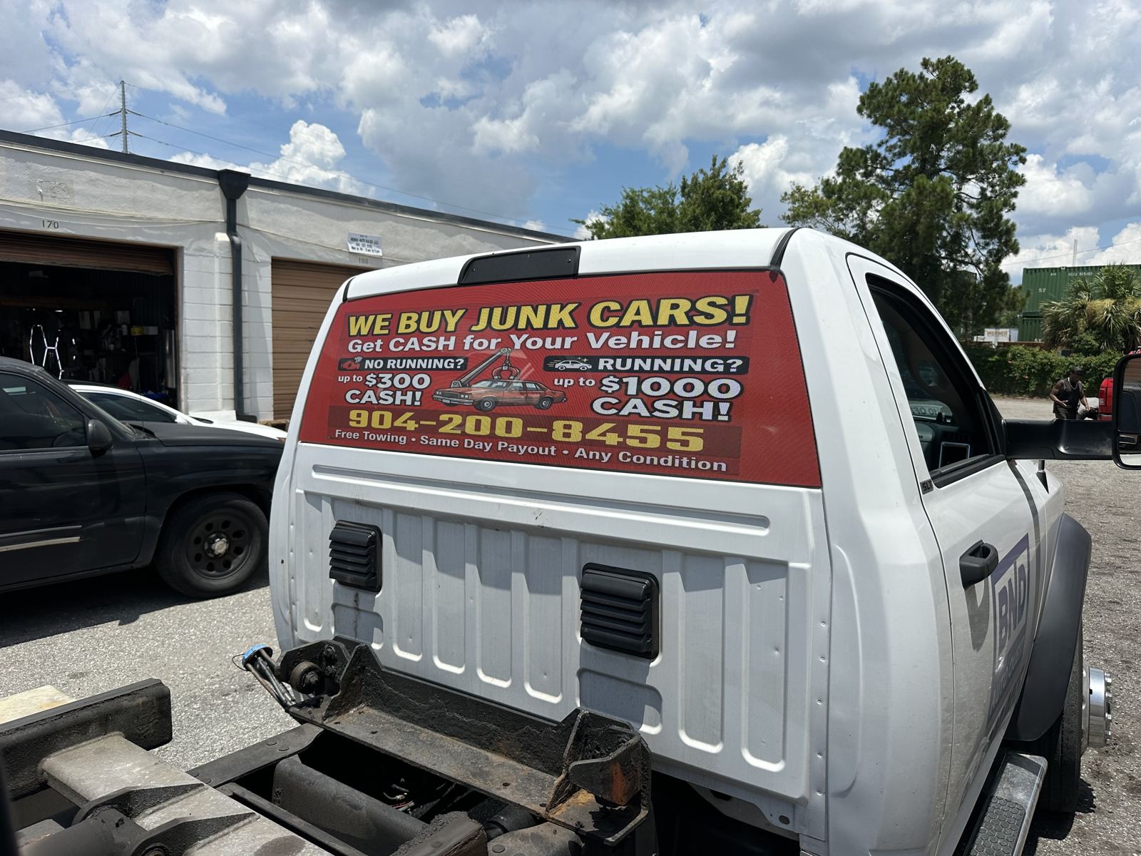 Vinil «We Buy Junk Cars» en grúa